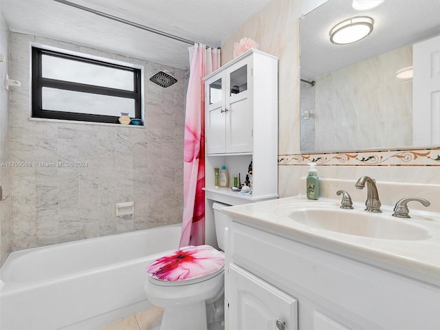 full bathroom featuring tile patterned floors, vanity, a textured ceiling, shower / bath combo with shower curtain, and toilet