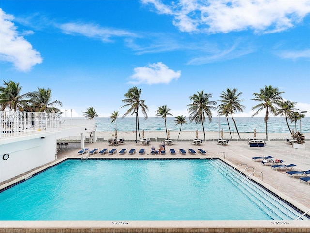 view of pool with a patio area and a water view