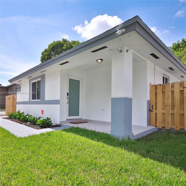 ranch-style home with a front yard and a patio