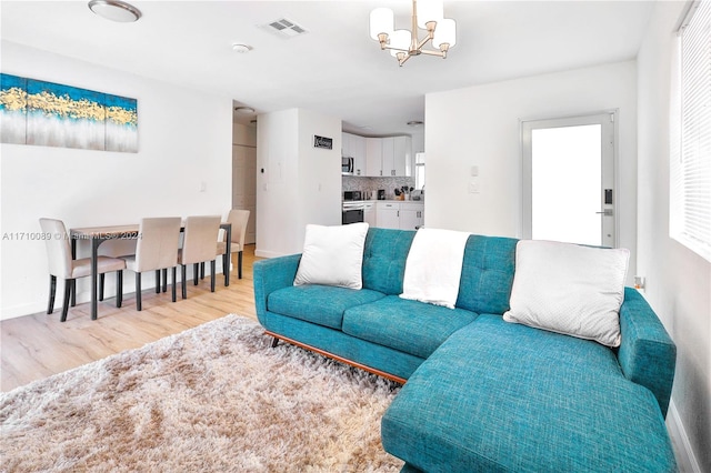 living room featuring light hardwood / wood-style flooring and a notable chandelier