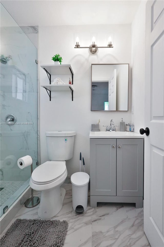 bathroom featuring a tile shower, vanity, and toilet