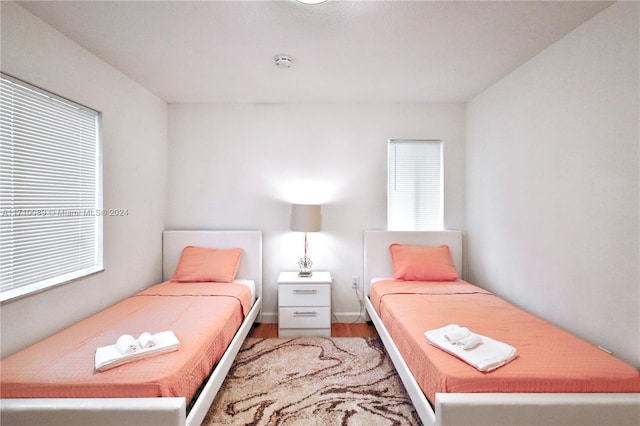 bedroom with multiple windows and hardwood / wood-style flooring