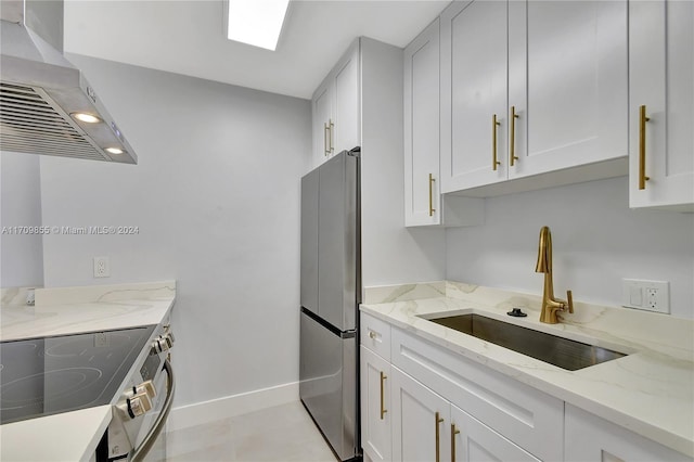 kitchen featuring sink, light stone counters, white cabinets, exhaust hood, and appliances with stainless steel finishes