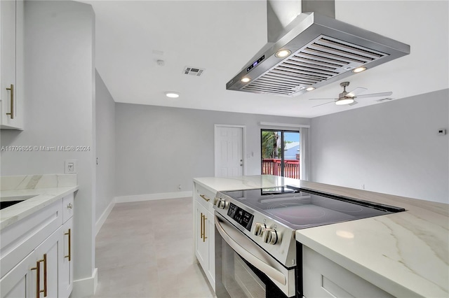 kitchen featuring electric stove, light stone counters, white cabinets, and island exhaust hood