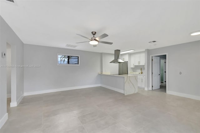 unfurnished living room featuring ceiling fan and sink