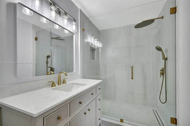 bathroom featuring a shower with door and vanity