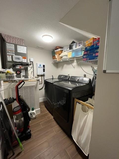 laundry room with separate washer and dryer, hardwood / wood-style floors, and a textured ceiling