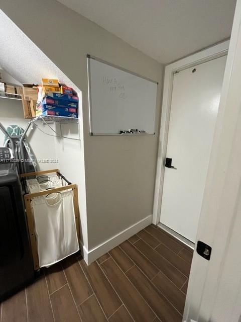 clothes washing area with dark hardwood / wood-style floors and washer / dryer