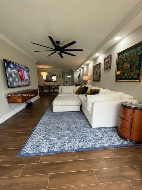 living room with ceiling fan and crown molding