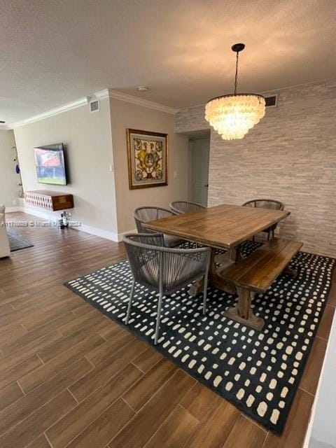 dining space featuring ornamental molding, dark wood-type flooring, and a chandelier