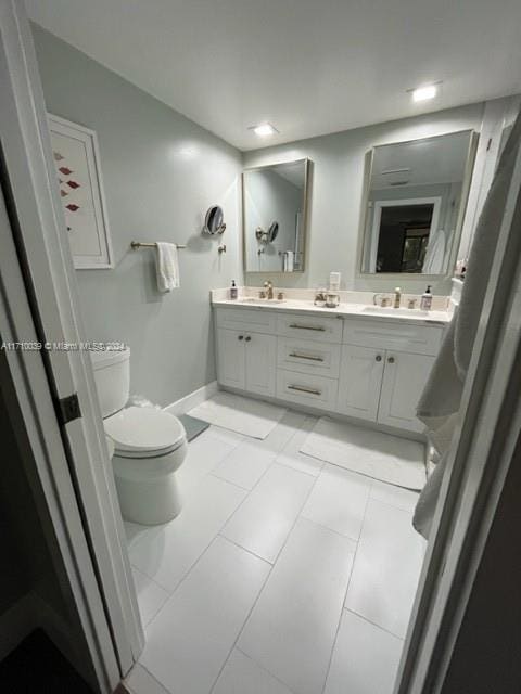 bathroom featuring tile patterned flooring, vanity, and toilet