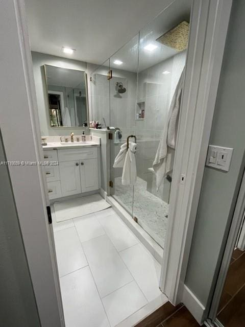 bathroom with tile patterned flooring, vanity, and a shower with shower door