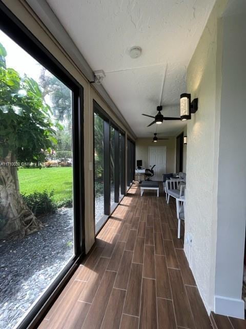 unfurnished sunroom featuring ceiling fan