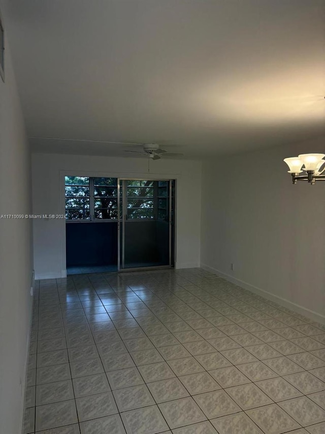 spare room with ceiling fan with notable chandelier