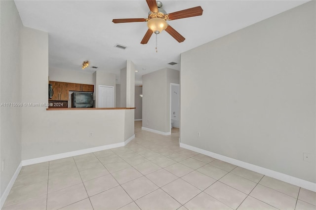 tiled spare room featuring ceiling fan