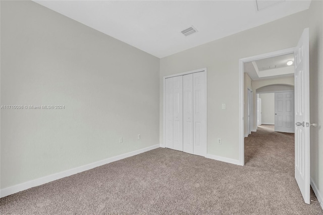 unfurnished bedroom featuring carpet flooring and a closet