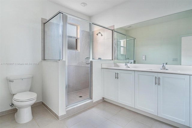 bathroom featuring tile patterned floors, vanity, toilet, and a shower with door