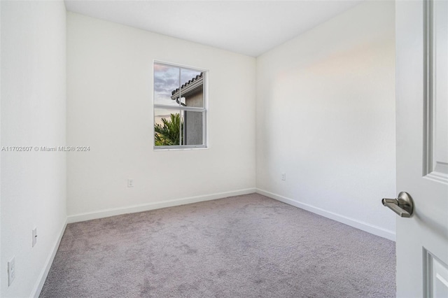 spare room featuring light carpet