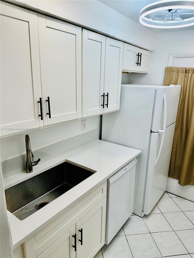 kitchen with white cabinets, dishwasher, light tile patterned floors, and sink