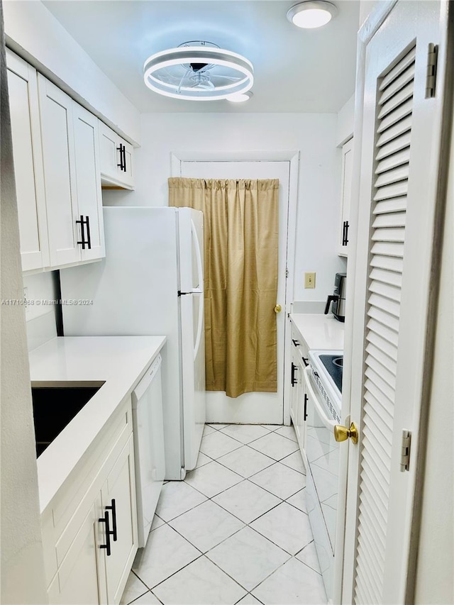 kitchen featuring white cabinets, light tile patterned flooring, white appliances, and sink