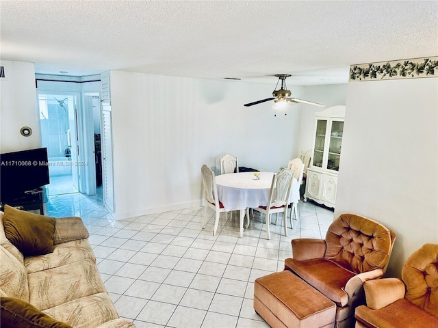 tiled dining space featuring ceiling fan and a textured ceiling