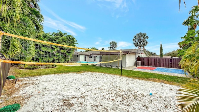 view of community featuring volleyball court and a yard