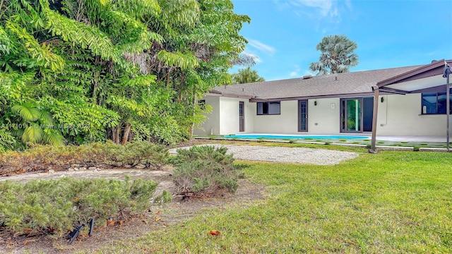 back of house with a lawn and a patio area