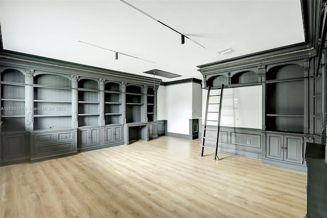 unfurnished living room featuring crown molding, rail lighting, and light wood-type flooring