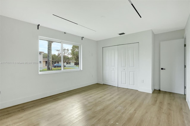 unfurnished bedroom featuring a closet and light wood-type flooring