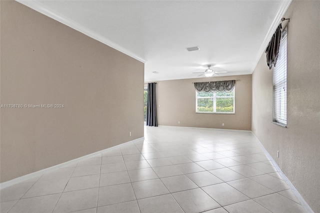 tiled empty room featuring crown molding and ceiling fan