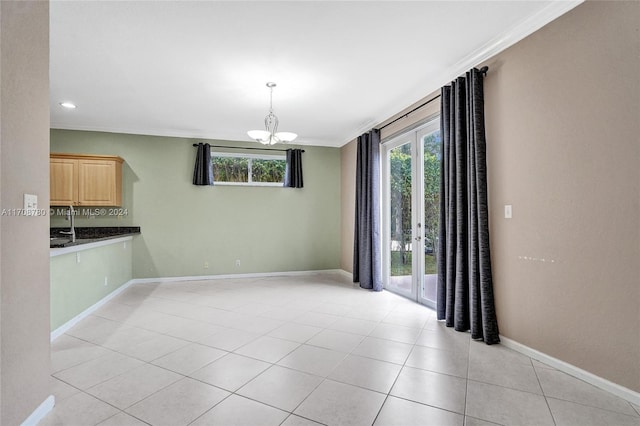 unfurnished dining area with light tile patterned floors, crown molding, and a chandelier