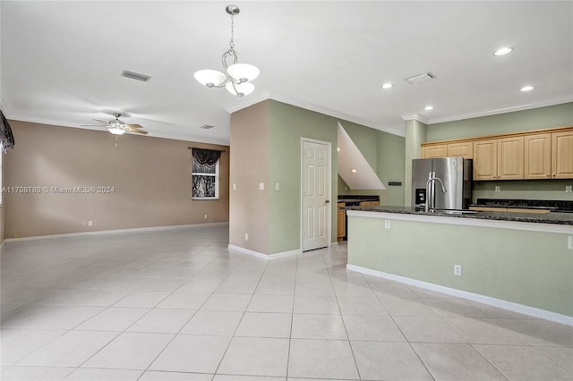 kitchen with stainless steel refrigerator with ice dispenser, ornamental molding, ceiling fan with notable chandelier, dark stone countertops, and light tile patterned flooring