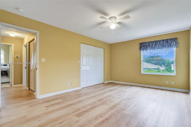 unfurnished bedroom featuring washer / dryer, light wood-type flooring, and ceiling fan