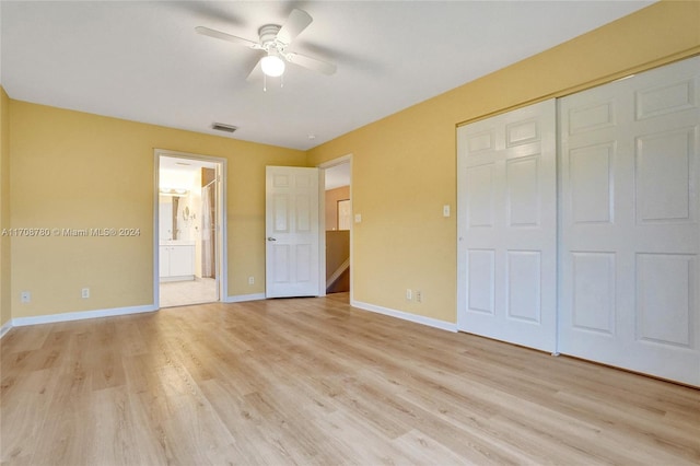 unfurnished bedroom featuring ceiling fan, a closet, connected bathroom, and light hardwood / wood-style flooring