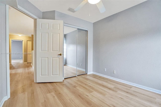 unfurnished bedroom featuring ceiling fan, light hardwood / wood-style floors, and a closet