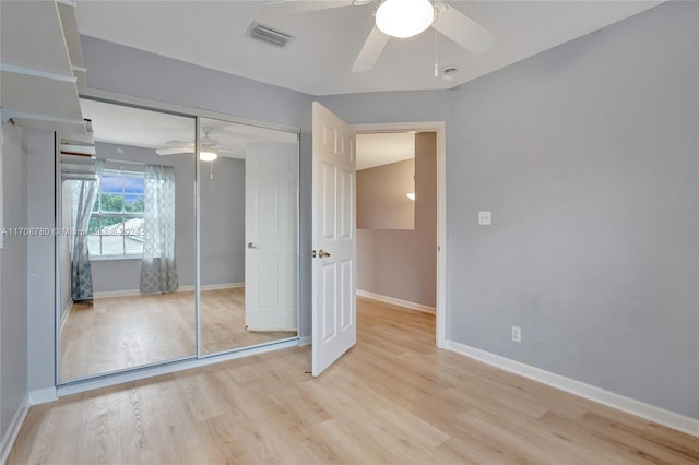 unfurnished bedroom featuring light hardwood / wood-style floors, a closet, and ceiling fan