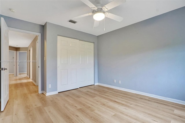 unfurnished bedroom featuring ceiling fan, a closet, and light hardwood / wood-style flooring