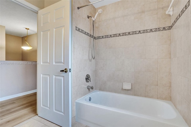 bathroom featuring tiled shower / bath combo and hardwood / wood-style flooring