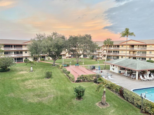 view of property's community featuring a lawn and a swimming pool