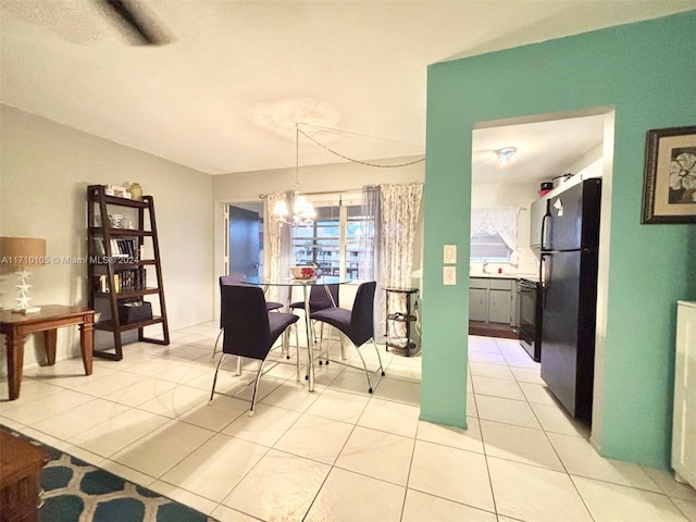 dining area with light tile patterned floors and an inviting chandelier