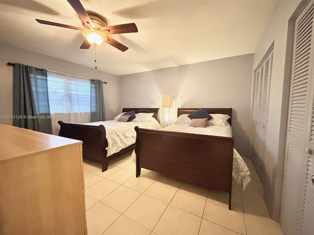 bedroom with ceiling fan and light tile patterned flooring