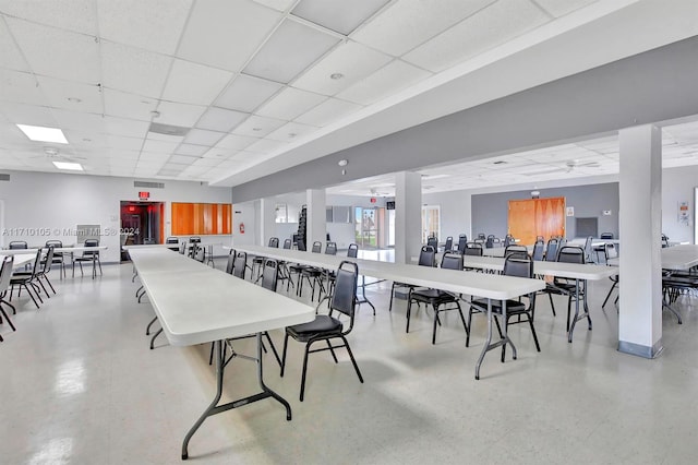 dining area with a drop ceiling and ceiling fan