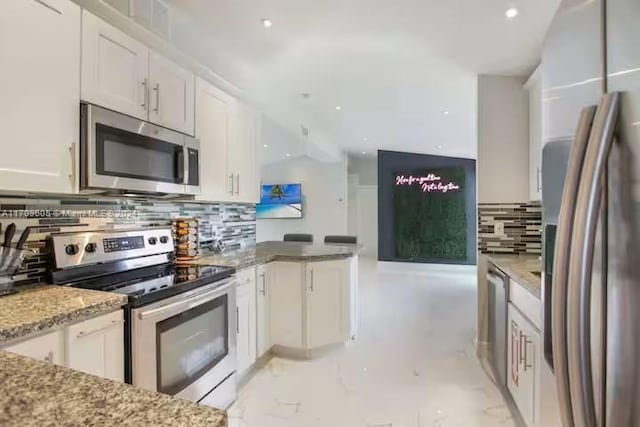 kitchen with decorative backsplash, light stone countertops, white cabinetry, and appliances with stainless steel finishes