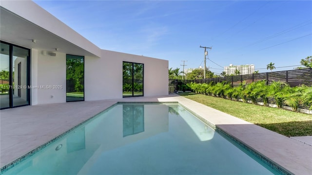 view of swimming pool featuring a patio and a lawn