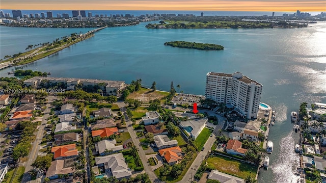 aerial view at dusk featuring a water view