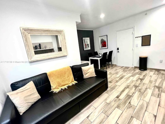 living room featuring light wood-type flooring and ornamental molding