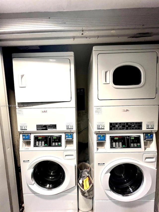 clothes washing area with stacked washing maching and dryer