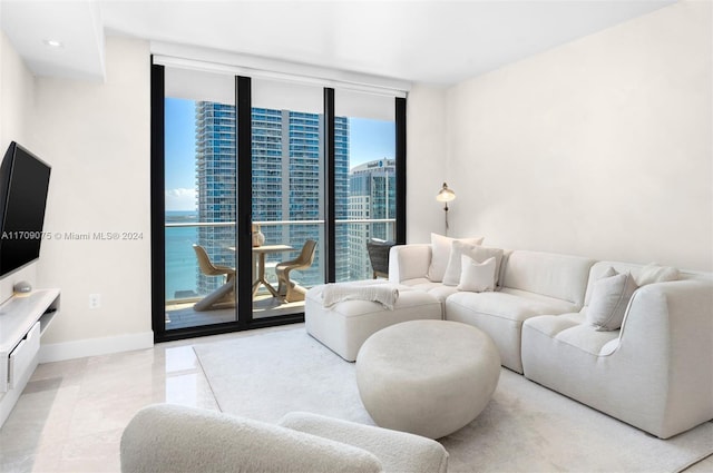 living room with a water view, a wall of windows, and a healthy amount of sunlight