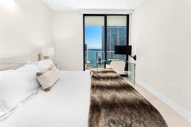 bedroom featuring access to exterior and a wall of windows