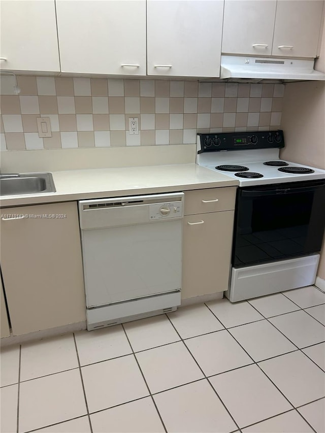 kitchen with sink, light tile patterned flooring, white appliances, decorative backsplash, and white cabinets